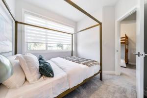 1 dormitorio con cama con dosel y ventana en Modern Nordic Escape, 3BR Near WEM & DT, AirCon & Fireplace, Wifi, Sleeps 6! en Edmonton