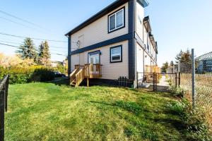 a house with a fence next to a yard at Modern Nordic Escape, 3BR Near WEM & DT, AirCon & Fireplace, Wifi, Sleeps 6! in Edmonton