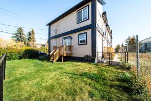 埃德蒙顿Modern Nordic Escape, 3BR Near WEM & DT, AirCon & Fireplace, Wifi, Sleeps 6!的院子旁有围栏的房子