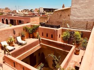 - une vue sur un bâtiment doté de plantes en pot dans l'établissement Riad AKL, à Marrakech