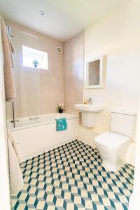 a bathroom with a toilet and a tub and a sink at Chestnut Cottage at Gravel Farm in Stretham +22 photos