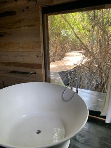 lavabo blanco en un baño con ventana en Dolce Ouidah Lodge en Ouidah
