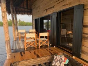 un portico di una cabina con sedie e tavolo di Dolce Ouidah Lodge a Ouidah