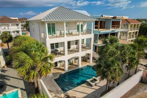 - une vue aérienne sur une maison avec une piscine et des palmiers dans l'établissement Magnolia Sands, à Destin