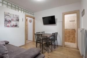 a living room with a table and chairs and a tv at StoneMlynska 7 Slovakia in Svit