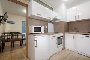 a kitchen with white appliances and a dining table at StoneMlynska 7 Slovakia in Svit