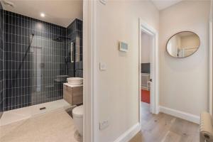 a bathroom with a toilet and a mirror at Apartments in the heart of Richmond, London in Richmond upon Thames +19 photos