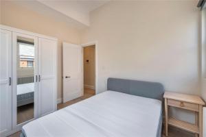 um pequeno quarto com uma cama e uma janela em Apartments in the heart of Richmond, London em Richmond upon Thames
