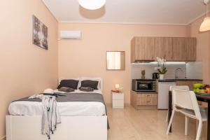 a small bedroom with a bed and a kitchen at COZY STUDIO in RETHYMNO TOWN in Rethymno