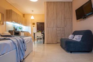 una camera con letto e sedia e una cucina di COZY STUDIO in RETHYMNO TOWN a Rethymno