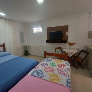 a bedroom with a bed and a flat screen tv at Loft Belas Praias in Arraial do Cabo