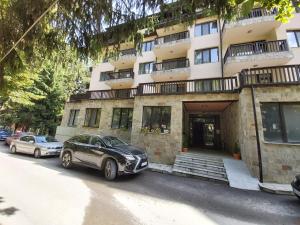 dois carros estacionados em frente a um edifício em Apartment Krasi em Velingrad