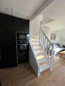 eine weiße Treppe im Wohnzimmer mit Küche in der Unterkunft Appartement T2 - port d'Orange in Saint-Pierre-Quiberon