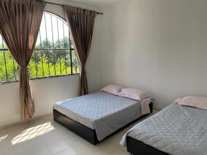 a bedroom with two beds and a large window at Villa Gabritali in La Mesa +33 photos