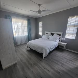 a bedroom with a large bed with white sheets and pillows at Villa Laks in Kiddʼs Beach