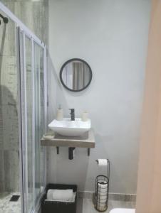 a bathroom with a sink and a shower and a mirror at Villa Laks in Kiddʼs Beach