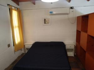 Habitación pequeña con cama y ventana en ALOJAMIENTO SERRANO BIS en Villa Giardino