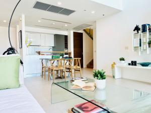 The river luxury two bedrooms في بانكوك: غرفة معيشة مع طاولة زجاجية ومطبخ