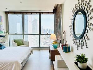 Schlafzimmer mit einem Bett und einem Schreibtisch mit einem Spiegel in der Unterkunft The river luxury two bedrooms in Bangkok