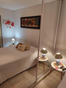 1 dormitorio con 1 cama y 2 mesas con lámparas en El Rincón de Juno en Córdoba