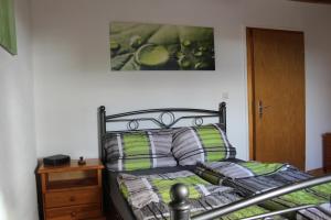sypialnia z łóżkiem z zielonymi i szarymi poduszkami w obiekcie Ferienwohnung an der Hundem w mieście Kirchhundem