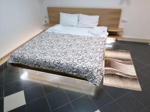 um quarto com uma cama com um edredão preto e branco em Restoran Filipovic em Nova Varos