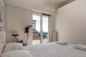 a bedroom with a bed and a large window at Piraeus Seaview Appartment in Piraeus