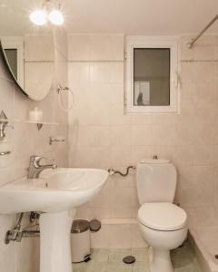 a bathroom with a toilet and a sink and a mirror at Piraeus Seaview Appartment in Piraeus