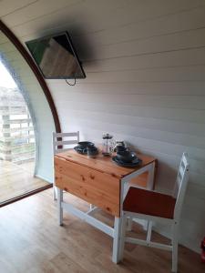 uma mesa de madeira e cadeiras num quarto em Handa pod in scottish highlands. em Scourie