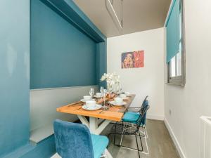 uma sala de jantar com uma mesa de madeira e cadeiras azuis em Your Central Stay 5 bedroom flat em Brighton & Hove