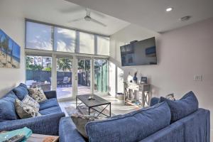 a living room with two blue couches and a tv at Canal-Front Condo Walk to Downtown Ft Lauderdale! in Fort Lauderdale