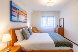 una camera da letto con un grande letto bianco e una lampada di Casa da Apúlia - Minho's Guest a Esposende Altre 28 foto