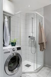 a washing machine in a bathroom with a shower at Koselig og sentralt midt i Fargegaten in Stavanger