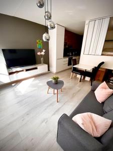 uma sala de estar com um sofá e uma mesa em Koselig og sentralt midt i Fargegaten em Stavanger