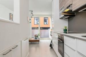 a kitchen with white cabinets and white counters at Koselig og sentralt midt i Fargegaten in Stavanger