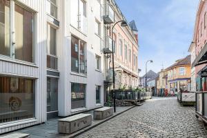 a cobblestone street in a city with buildings at Koselig og sentralt midt i Fargegaten in Stavanger