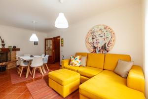 een woonkamer met een gele bank en een tafel bij Casa da Apúlia - Minho's Guest in Esposende