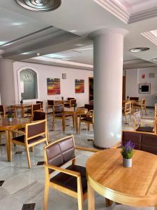 HOTEL LA FONDA DE DON GONZALO في ثينيس دي لا فيغا: غرفة طعام مع طاولات وكراسي خشبية