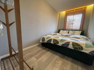 1 dormitorio con 1 cama y suelo de madera en Ideal Apartment n4, en Pristina