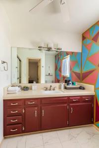 a bathroom with a sink and a large mirror at Tortoise Oasis - Hot tub, Shuffleboard, & More! in Yucca Valley +43 photos