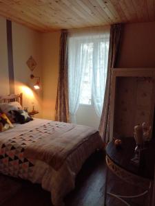 um quarto com uma cama e uma janela em Chez Lorette em Mauzé-sur-le-Mignon