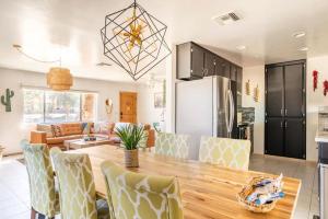 a kitchen and living room with a wooden table and chairs at Tortoise Oasis - Hot tub, Shuffleboard, & More! in Yucca Valley