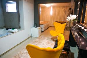 - un salon avec des chaises jaunes et une table dans l'établissement Hotel Pedra Negra Gov. Valadares, à Governador Valadares
