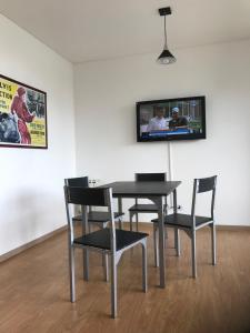 d'une table, de chaises et d'une télévision murale. dans l'établissement Departamento Puerto Norte, à Rosario