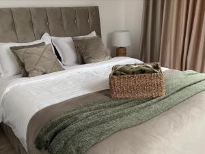 a bed with a green blanket and a basket on it at Bella Vista Cheia in Cheia