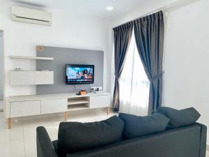 Una sala de estar con un sofá y un televisor. en Apartment@Mansion One Georgetown, en George Town