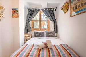 Dar BAB HAHA Petite Maison à la Marocaine في طنجة: غرفة نوم عليها سرير وفوط