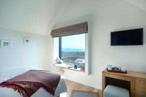 a bedroom with a bed and a window with a view at Skye Eyrie in Staffin