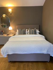 a bedroom with a large bed and a mirror at The Old Stable in Bugbrooke