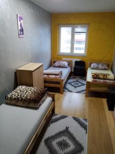 a room with three beds and a window at Prenociste DUGA in Užice